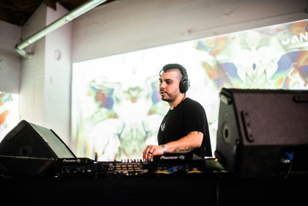 a man in a black shirt is playing a dj set